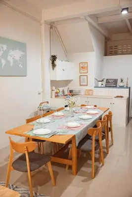a kitchen with a wooden table and chairs in a kitchen at Spacious Relaxing Townhouse with Rooftop in Ekamai in Bangkok