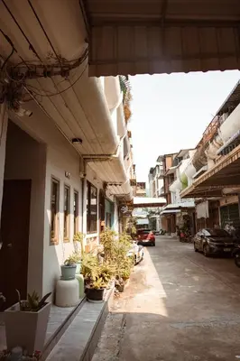 an alley with potted plants on the side of a building at Spacious Relaxing Townhouse with Rooftop in Ekamai in Bangkok