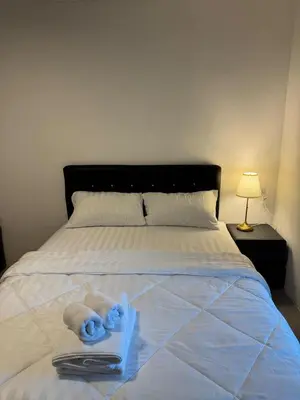 a bed with two towels and a book on it at Natthapimon in Bangkok Yai