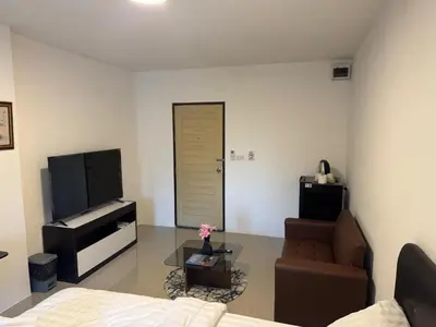 a living room with a couch and a television at Natthapimon in Bangkok Yai