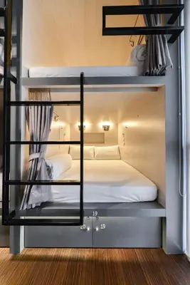 a room with two bunk beds with white sheets at The Cube Hostel Silom in Bangkok