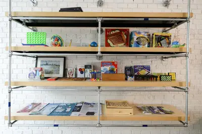 a shelf with books and other items on it at The Cube Hostel Silom in Bangkok