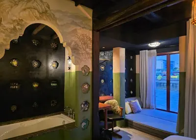 a bathroom with a bath tub and a bedroom at Siamotif Boutique Hotel in Bangkok
