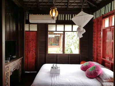 a bedroom with a bed with pink pillows and a window at Siamotif Boutique Hotel in Bangkok