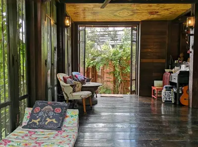 a screened in porch with a couch and chairs at Siamotif Boutique Hotel in Bangkok