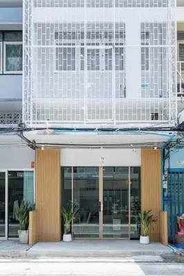 a building with two potted plants in front of it at 72 House & Cafe in Phra Khanong