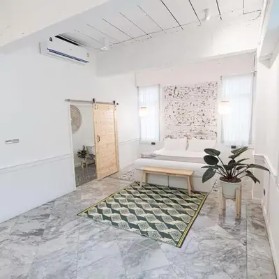 a large white bathroom with a tub and a potted plant at The Local Heritage Loft Mansion in Bangkok