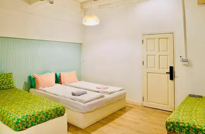 a room with two beds and a door at The Local Heritage Loft Mansion in Bangkok