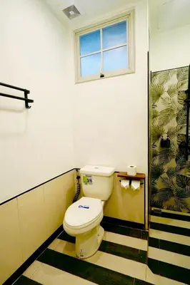 a bathroom with a toilet and a window at The Local Heritage Loft Mansion in Bangkok