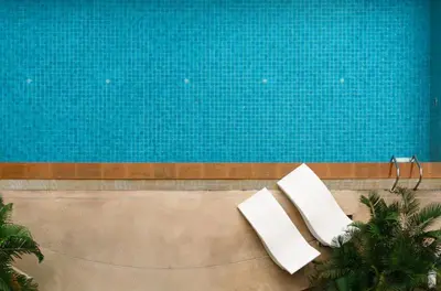 two white chairs sitting next to a swimming pool at Executive 2 Bed Nana BTS 100m Bangkok Skyline in Bangkok