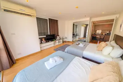 a bedroom with two beds and a living room at Cozy, Spacious 2-Bedder with City, Park View, Near Nana BTS in Bangkok