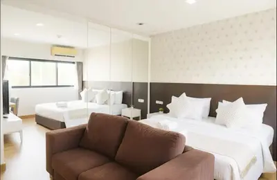 a hotel room with two beds and a couch at City Center Nana 4-Guest Suite 100m Nana BTS in Bangkok