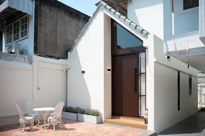 a patio with a table and chairs in front of a building at Morya House in Bangkok
