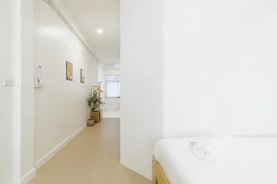 a white room with a bed and a hallway at A Townhouse 100m from BTS Bangchak in Phra Khanong