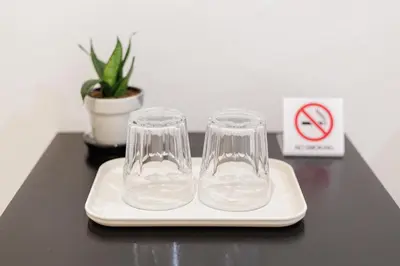 two empty glasses sitting on a plate on a table at A Townhouse 100m from BTS Bangchak in Phra Khanong