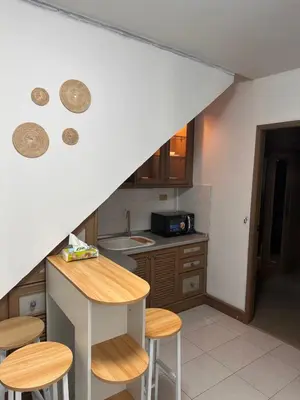 a kitchen with a counter and some stools in it at Regalohome Br in Bangkok