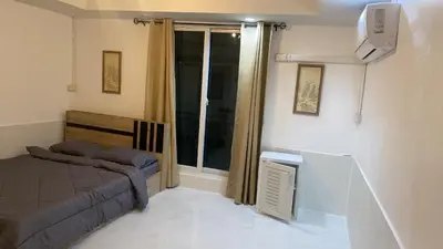 a small bedroom with a bed and a window at Am Am Place แอม แอม เพลส in Bangkok