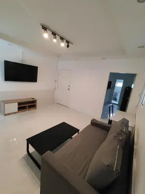 a living room with a couch and a flat screen tv at Am Am Place แอม แอม เพลส in Bangkok