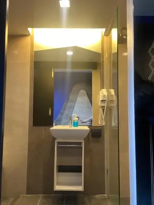 a bathroom with a sink and a mirror at The Xtreme Suites in Bangkok