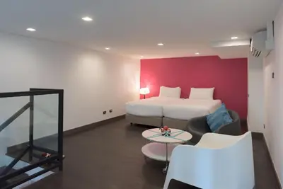 a hotel room with a bed and a table at The Xtreme Suites in Bangkok