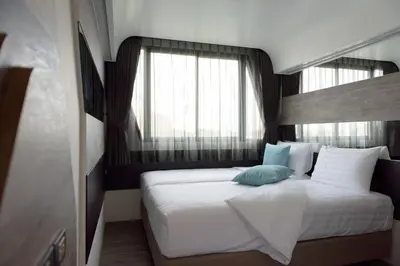 a bedroom with a large white bed with a window at The Xtreme Suites in Bangkok