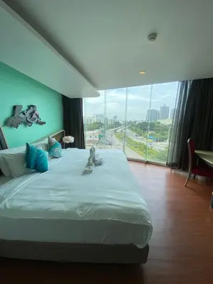 a bedroom with a large bed with a large window at The Xtreme Suites in Bangkok