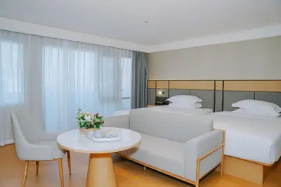 a hotel room with two beds and a table at \u66fc\u8c37\u4e1c\u65b9\u9152\u5e97 in Bangkok