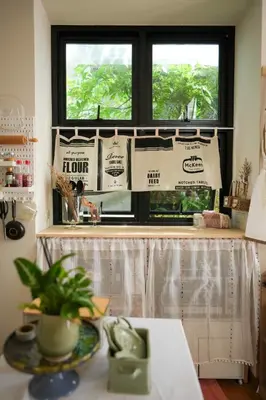 a kitchen with a window and a table with a plant at hiddenmoon cottage in Bangkok