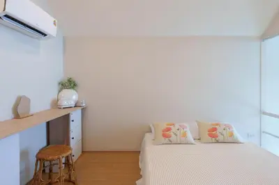 a bedroom with a bed and a desk and a chair at hiddenmoon cottage in Bangkok