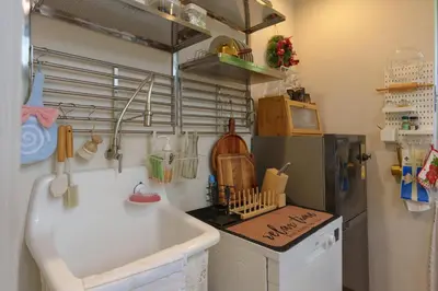 a kitchen with a sink and a refrigerator at hiddenmoon cottage in Bangkok
