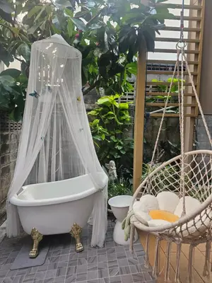 a bath tub with a canopy on a patio at hiddenmoon cottage in Bangkok