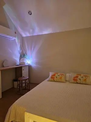 a bedroom with a bed and a purple light at hiddenmoon cottage in Bangkok