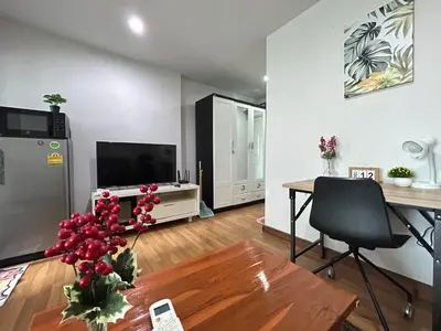 a living room with a table and a television at Perfect 1BR at MRT Bangson by B in Bangkok