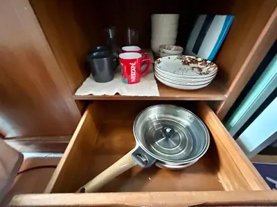 a cabinet with a pot and a bowl and plates at Perfect 1BR at MRT Bangson by B in Bangkok