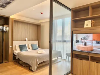 a bedroom with a bed and a glass wall at Circle 31 #1BR Bangkok in Bangkok