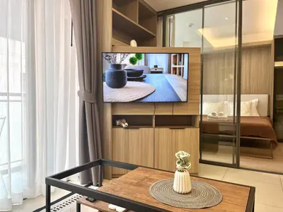 a living room with a tv on a wall at Circle 31 #1BR Bangkok in Bangkok