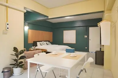 a bedroom with a bed and a white table and chairs at XX GO INN The Grand Palace - MRT Samyot Station in Bangkok