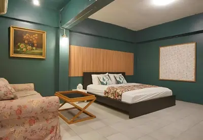 a bedroom with a bed and a couch at XX GO INN The Grand Palace - MRT Samyot Station in Bangkok