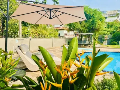 a patio with an umbrella and a pool at 5BR Villa with Private Pool Sukhumvit 10mins BTS in Bangkok