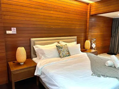 a bedroom with a white bed with wooden walls at 5BR Villa with Private Pool Sukhumvit 10mins BTS in Bangkok