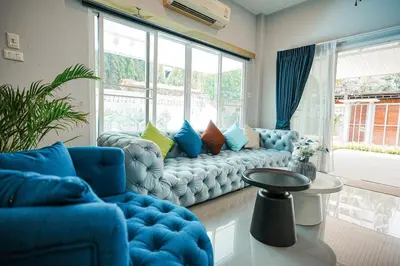 a living room with a blue couch and a large window at 906 Bangkok City Center Single Pool Villa BTS Asok 5 Bedrooms 6 Bathrooms in Bangkok