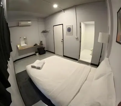 a room with a large white bed and a mirror at XX GO INN BTS Ari - BTS Ari Station in Sathani Sam Sen