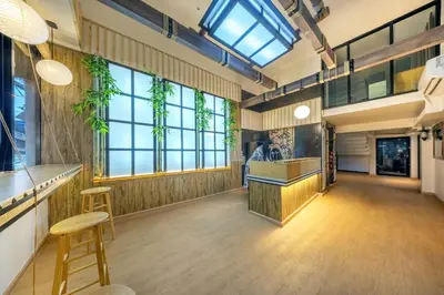 a lobby with a bar and stools and windows at SHIN Hotel Victory Monument in Bangkok