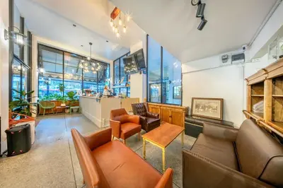a lobby with couches and chairs and a bar at SHIN Hotel Victory Monument in Bangkok