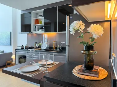 a kitchen with a table with plates and flowers in a vase at Expansive Loft 2BR - Ultra Fast WiFi - BTS Thonglor in Bangkok