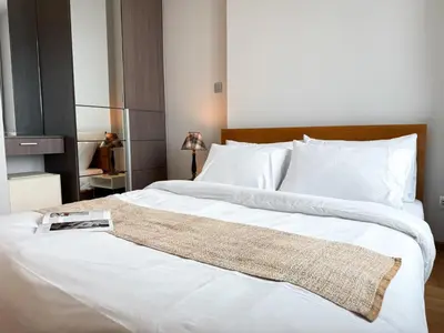 a bedroom with a large white bed with a book on it at Expansive Loft 2BR - Ultra Fast WiFi - BTS Thonglor in Bangkok