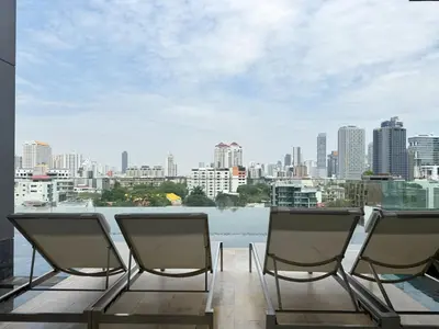 two chairs on a balcony with a view of a city at Expansive Loft 2BR - Ultra Fast WiFi - BTS Thonglor in Bangkok