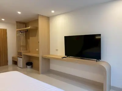 a living room with a tv on a wall at Luna Residence in Ban Bang Phai