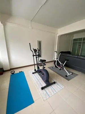 a gym with two exercise bikes and a couch at Homey Place 2 in Ban Song Hong