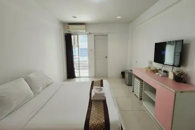 a living room with a large bed and a tv at Zenith Life Hotel in Ban Bang Khen (1)